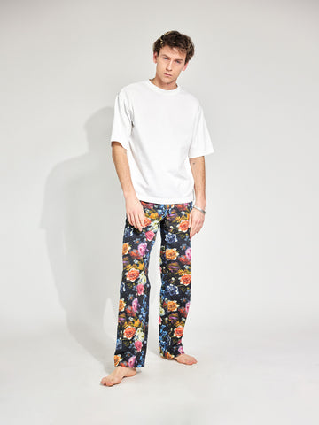 Mann trägt Hose im Pyjama-Style aus Baumwolle mit tiefen Hosentaschen und bunten Blumenmuster