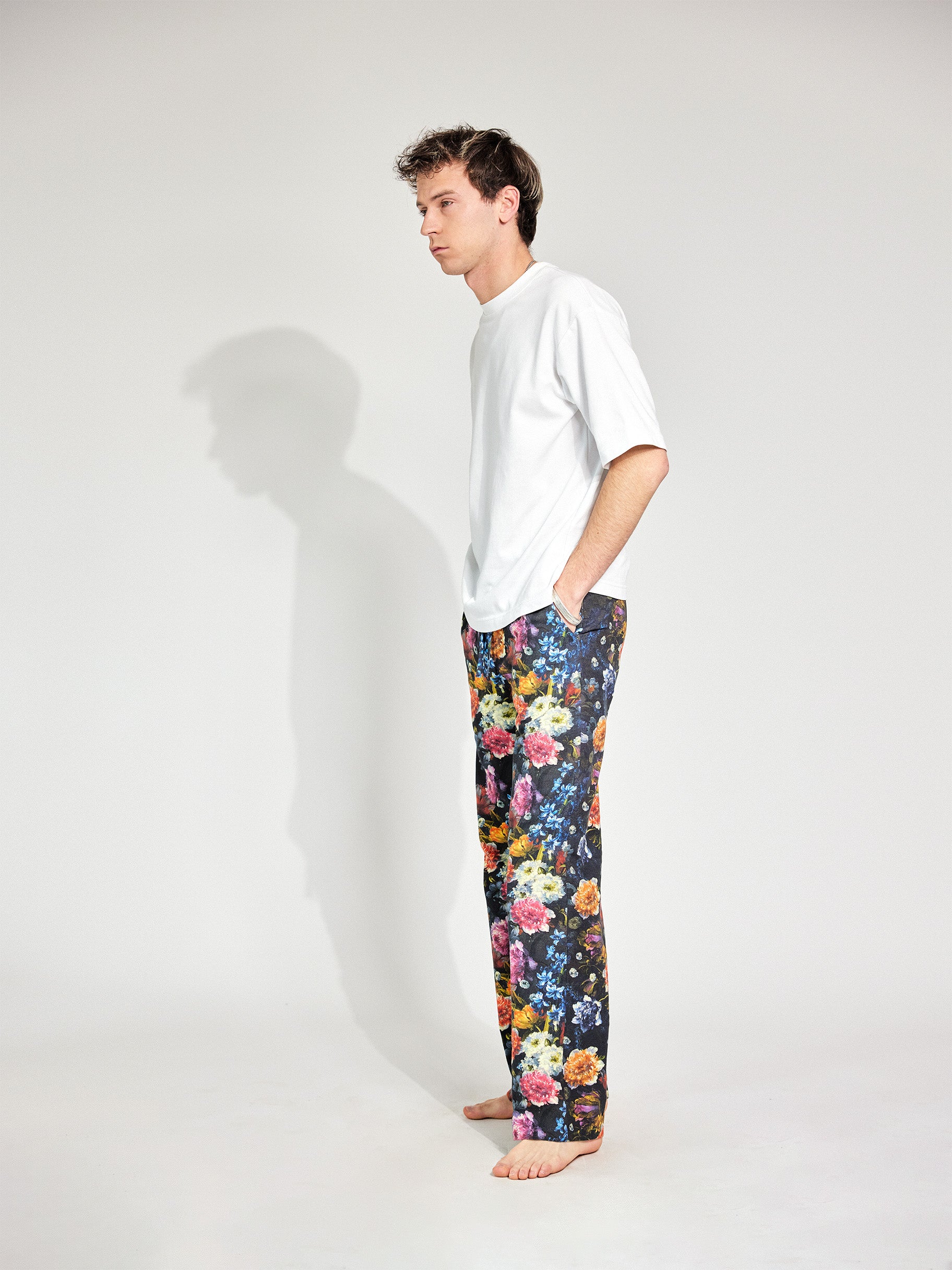 Mann trägt Hose im Pyjama-Style aus Baumwolle mit tiefen Hosentaschen und bunten Blumenmuster